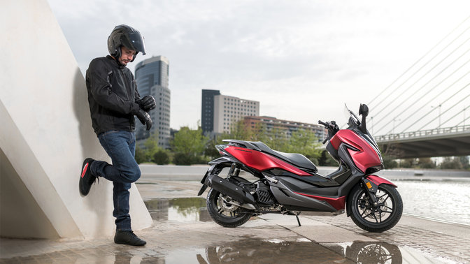 Motocykl Honda Forza zaparkovaný ve městě