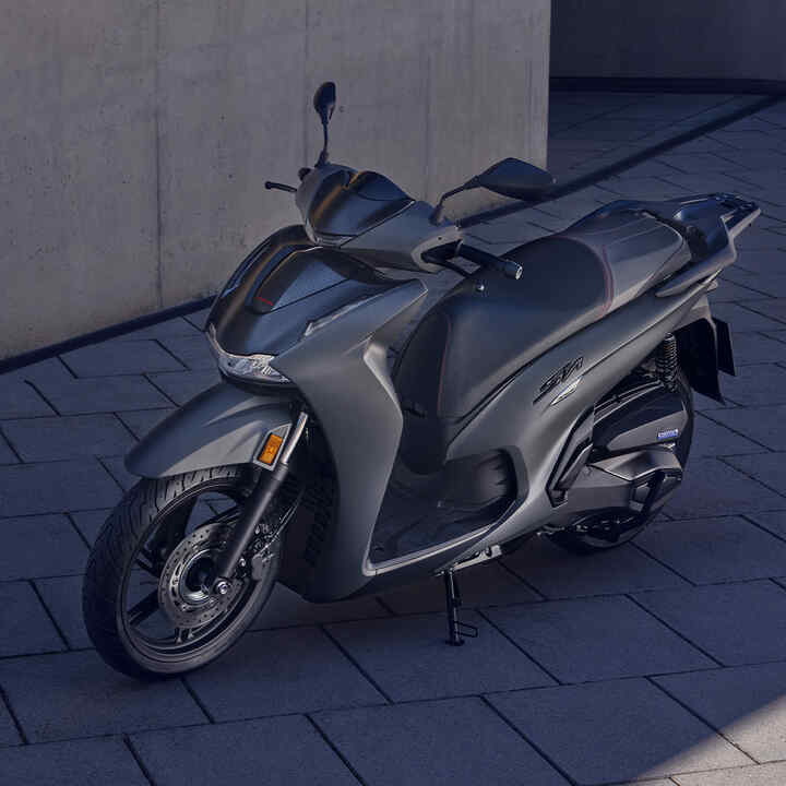 Přední tříčtvrtinový pohled na skútr Honda SH350i stojící na dvoře