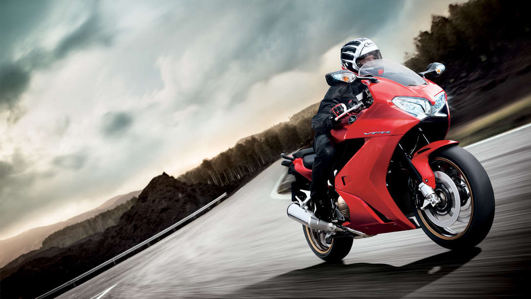 Tourer Honda VFR800F v barvě Victory Red při jízdě na silnici