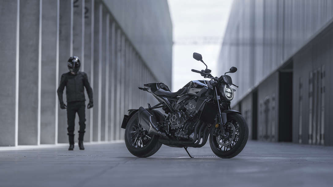 Honda CB1000R Black Edition – muž stojící vedle motocyklu na ulici mezi budovami