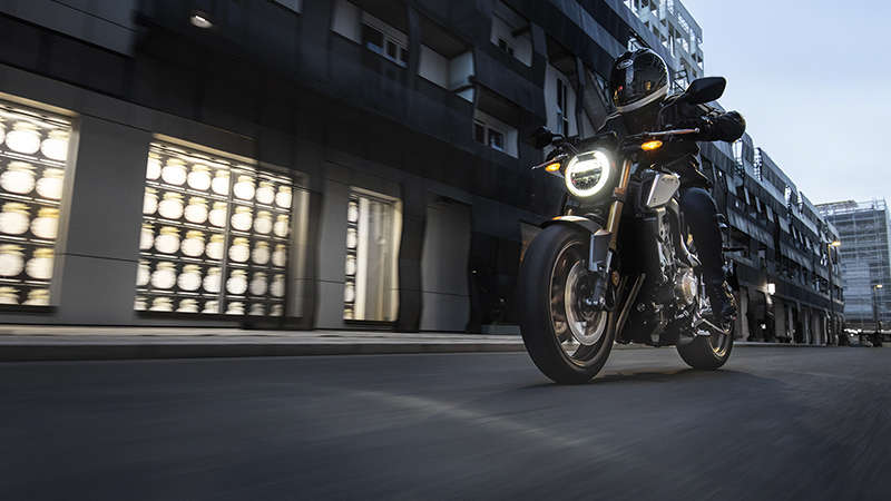 CB650R Neo Sports Café, přední levý poloprofil, s jezdcem, ve městě za tmy