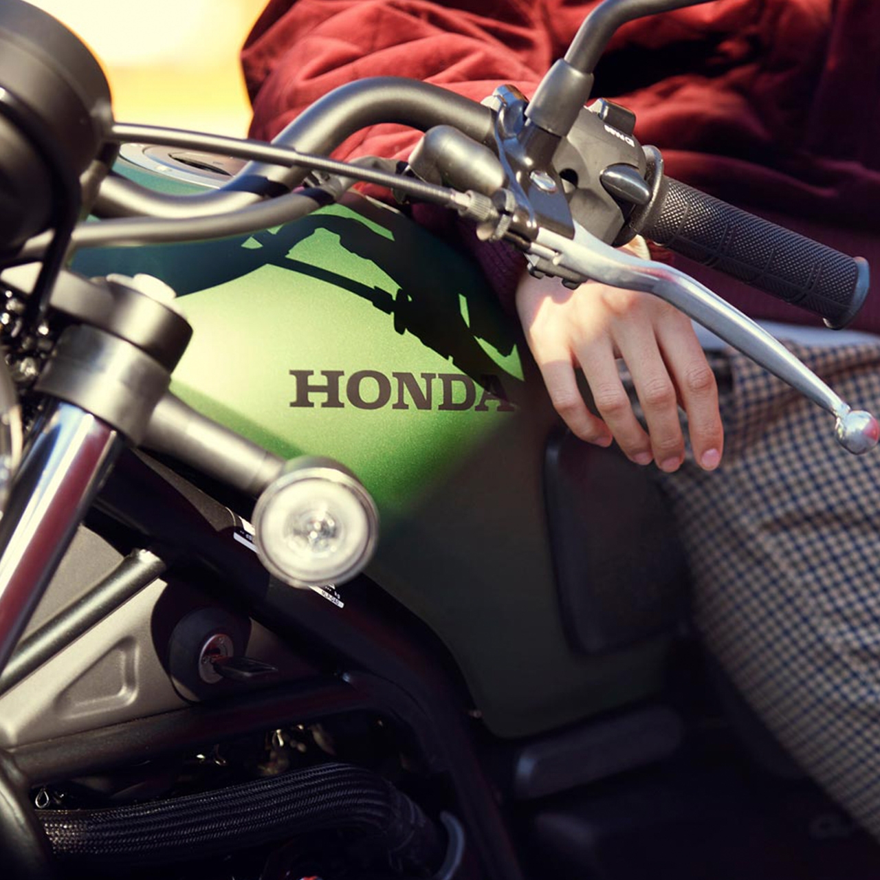 Detailní boční pohled na motocykl Honda CL500 s figurantem.