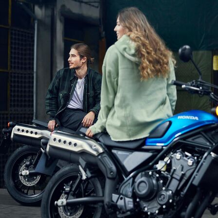 Honda CL500 s figuranty sedícími na motocyklu.