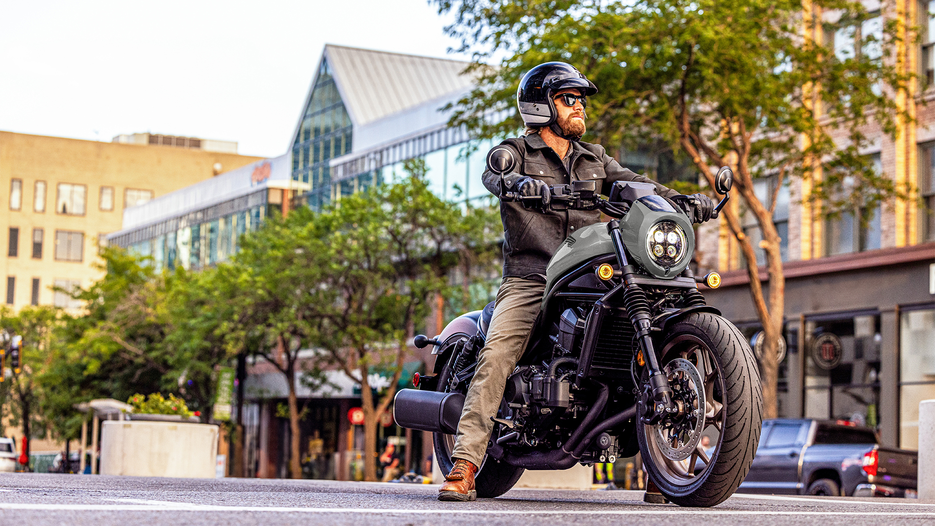 Záběr zepředu na figuranta na motocyklu Honda CMX1100 ve městě