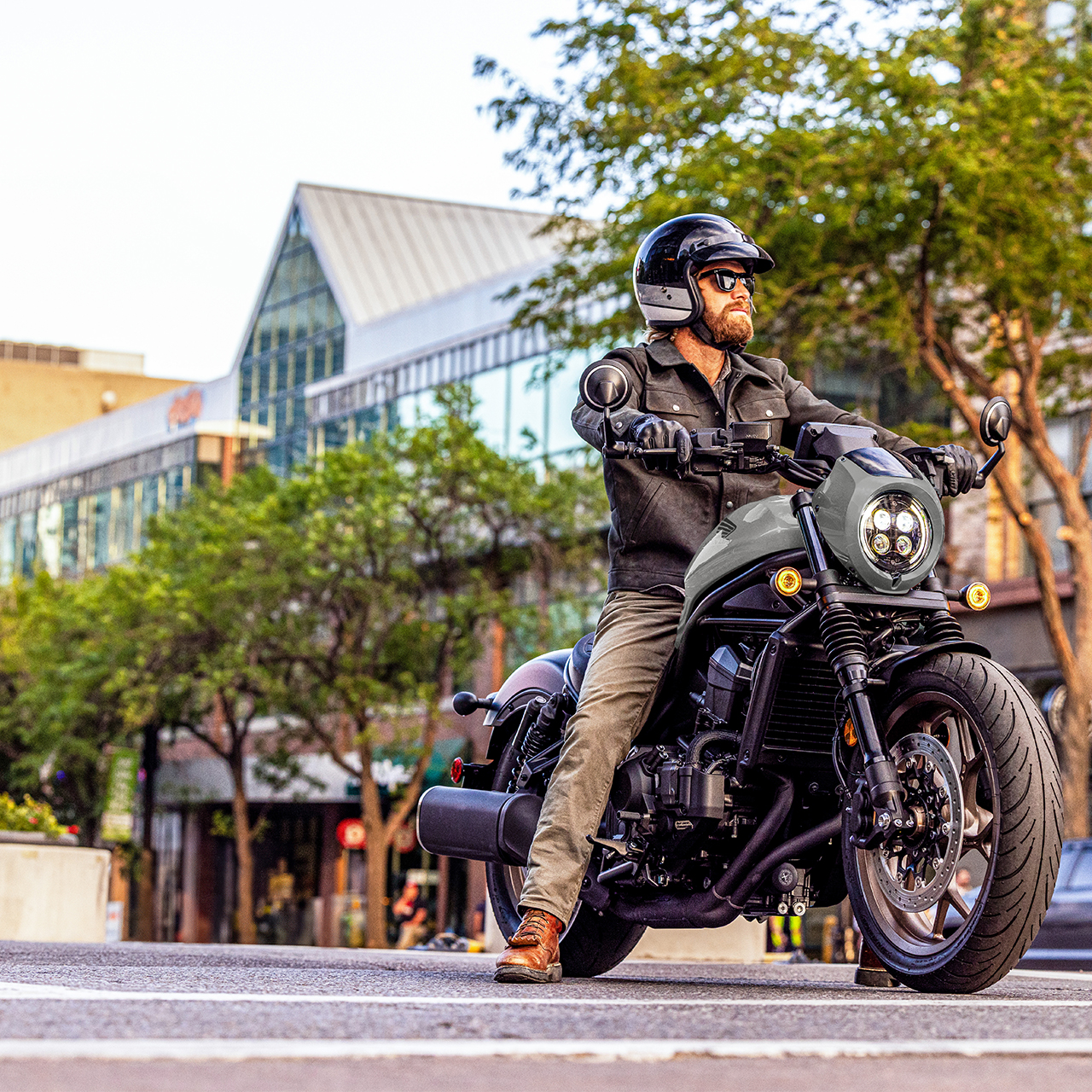 Záběr zepředu na figuranta na motocyklu Honda CMX1100 ve městě