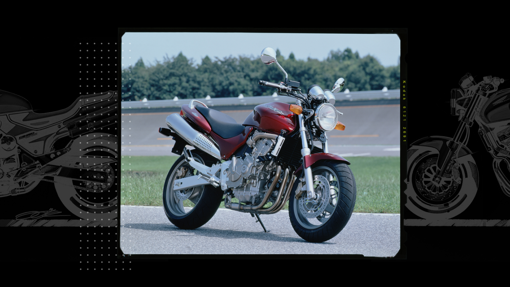 Tříčtvrtinový pohled zepředu na Hondu Hornet zaparkovanou na závodní dráze.