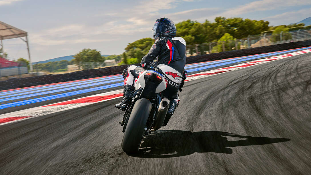 Zadní strana motocyklu Honda CBR1000RR-R Fireblade s jezdcem na závodní dráze