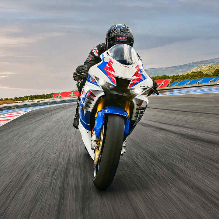 Pohled zepředu na jezdce na motocyklu Honda CB900RR Fireblade na závodní dráze