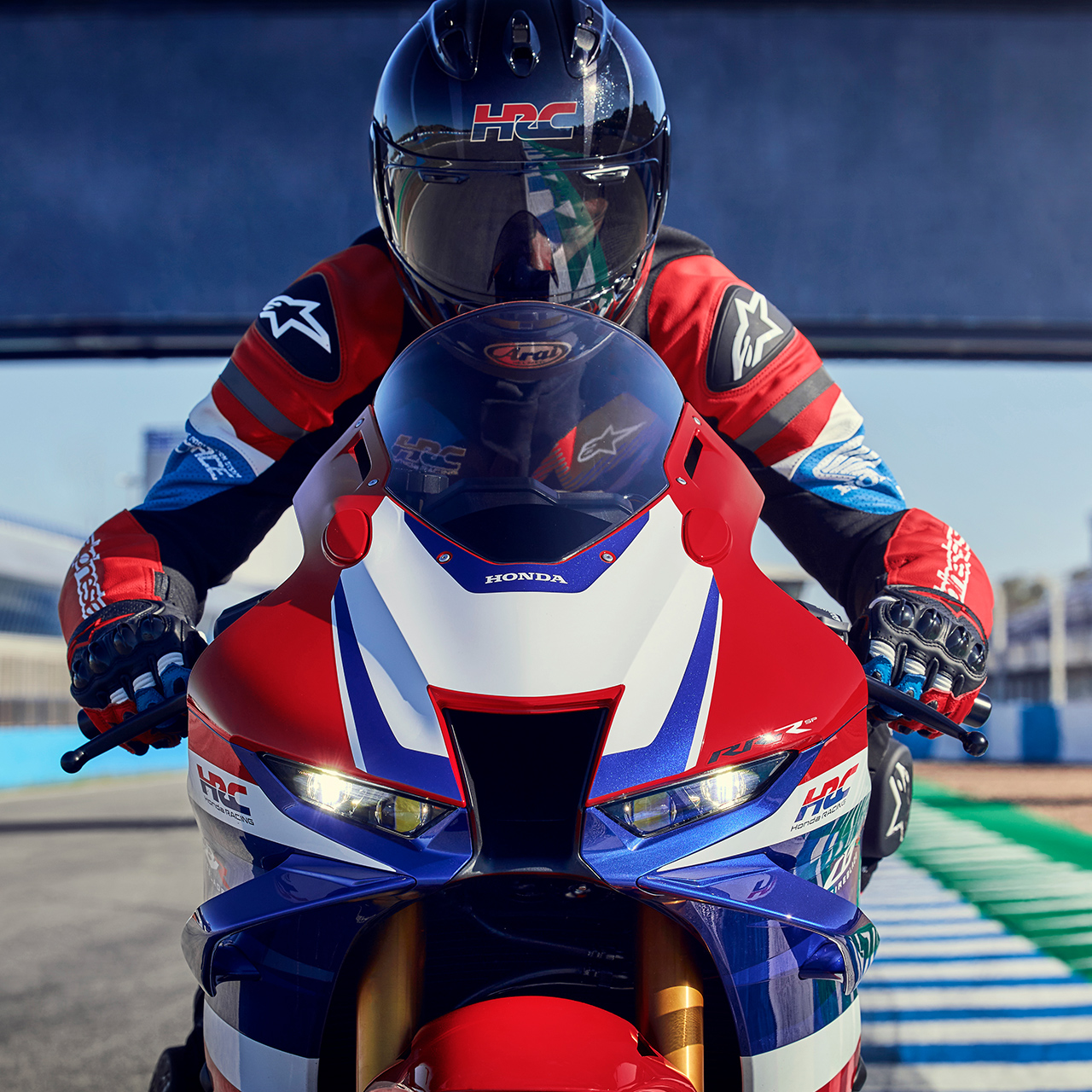 Detailní pohled zepředu na jezdce na trati na motocyklu Honda CBR1000RR-R Fireblade. 