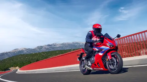 Motocykl Honda CBR650R, snímek z boku, zaparkovaný před budovou 